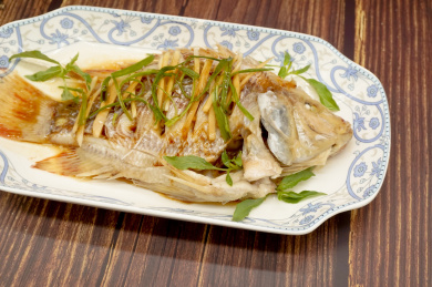 木桌背景中的一盘清蒸花雕鱼