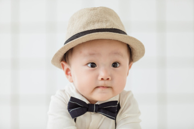白色衬衫领结和黑色帽子的亚裔男童