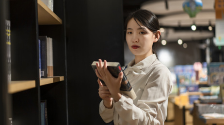 一位年轻女性在图书馆看书