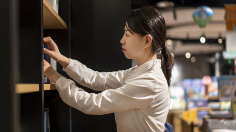 一位年轻女性在图书馆看书