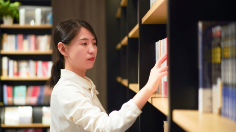 一位年轻女性在图书馆看书