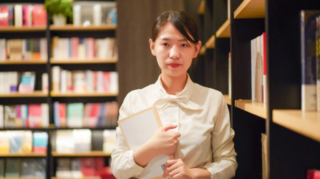 一位年轻女性在图书馆看书