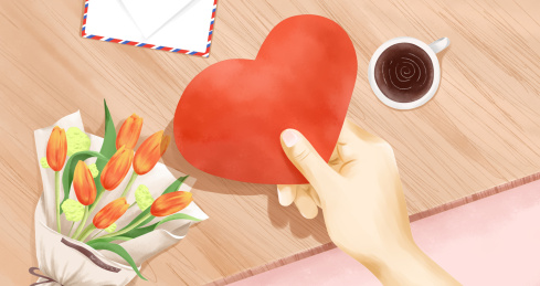 在摆放着郁金香鲜花的桌面手拿着爱心卡片插