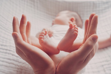 双手握捧住新生宝宝的双脚