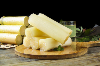 木板上放着一堆去皮黑皮甘蔗