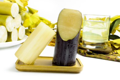 白底木板上放着两节黑皮甘蔗