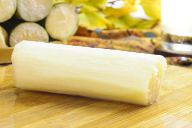 木板上放着一节去皮的甜甘蔗