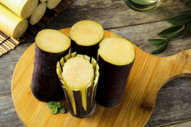 灰底木板上放着四节黑皮甘蔗