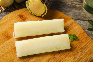 木板上放着切开的黑皮甘蔗