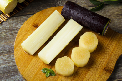 木板上放着切开的黑皮甘蔗