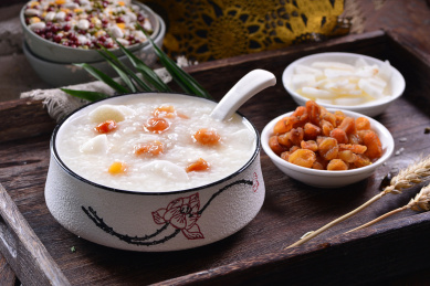 一碗桂圆山药粥放在木制底板上