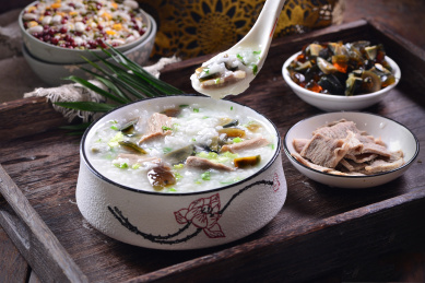 一碗牛肉皮蛋粥放在木制底板上