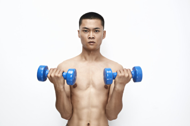 使用哑铃进行健身锻炼的亚洲男性