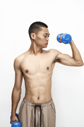 使用哑铃进行健身锻炼的亚洲男性