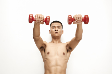 使用哑铃进行健身锻炼的亚洲男性