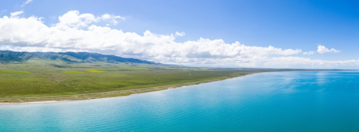 航拍蓝天白云下的青海湖与湖边的山