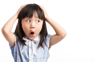 小女孩双手抱头吃惊的看向一边