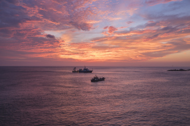 航拍日出朝霞下海上捕鱼的船