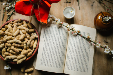 桌上放着一本书和一支白梅花