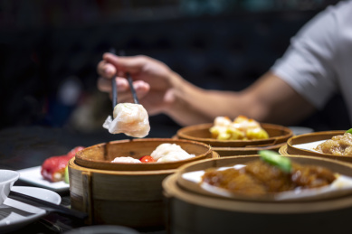 一个人品尝餐桌上的水晶虾饺