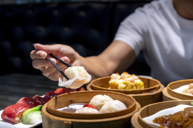 一个人品尝餐桌上的水晶虾饺