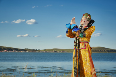 草原上穿着蒙古族服饰的年轻少女