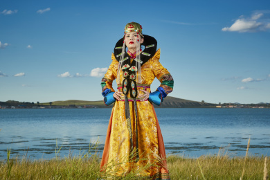 草原上穿着蒙古族服饰的年轻少女