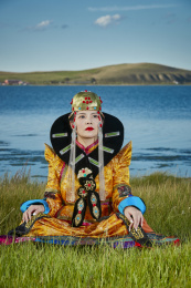 草原上穿着蒙古族服饰的年轻少女