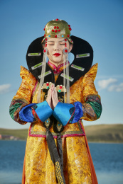 草原上穿着蒙古族服饰的年轻少女