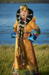 草原上穿着蒙古族服饰的年轻少女