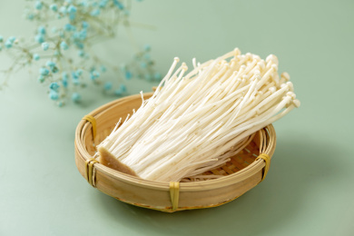 金针菇摆放在绿色莫兰迪色系背景上