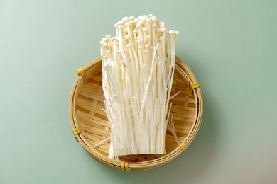 金针菇摆放在绿色莫兰迪色系背景上