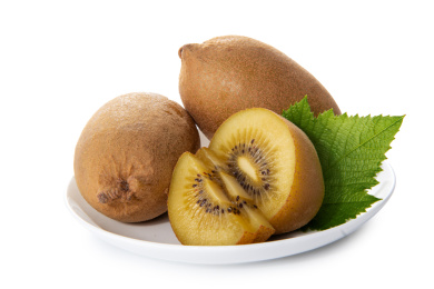 猕猴桃和切开果肉带绿叶子装白盘白底