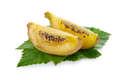 猕猴桃切开两块果肉带绿叶子白底