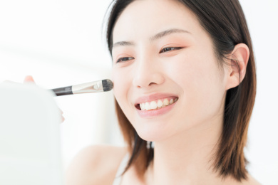 照镜子化妆的年轻东方女性