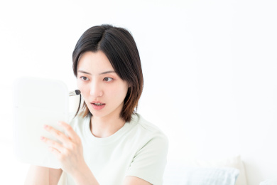 照镜子化妆的年轻东方女性