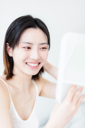 照镜子化妆的年轻东方女性