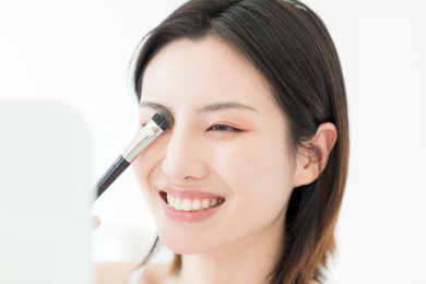 照镜子化妆的年轻东方女性