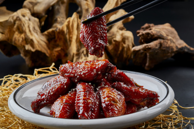 圆形瓷盘装的秘制酱烧鸡翅中