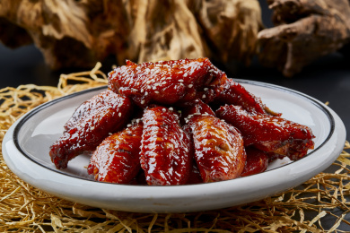 圆形瓷盘装的秘制酱烧鸡翅中