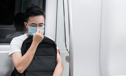 年轻男人坐在地铁里调整口罩