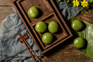 一碟小吃青团放着木板背景上的蓝布上