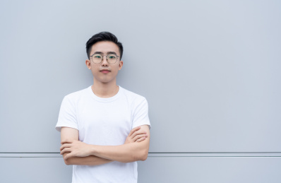 自信的亚洲男青年双手环抱正面