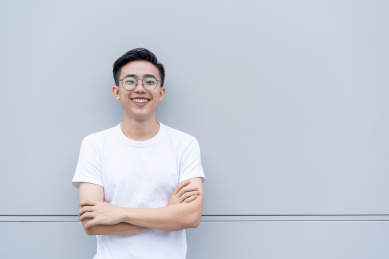 自信的亚洲男青年双手环抱正面