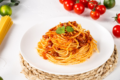 满满一盘肉酱意大利面放在白色水泥板上