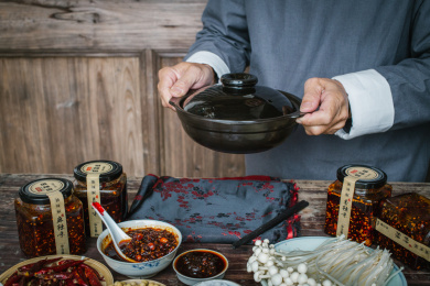 餐桌上放着辣椒酱，正在上菜的动作