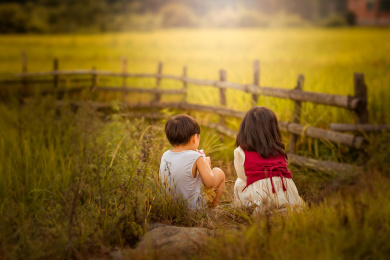 夕阳下一个身着裙子的小姑娘走在稻田间游玩
