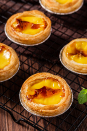 木板背景上的美味蛋挞