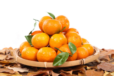 地上叶子上放着一筐薄皮小橘子