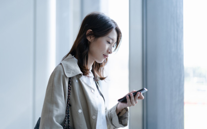 拿着手机的女士在低头看手机